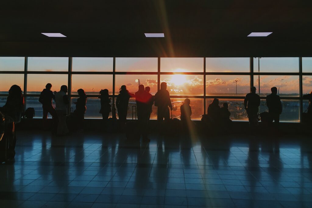 Airline passengers looking out window during a sunset.